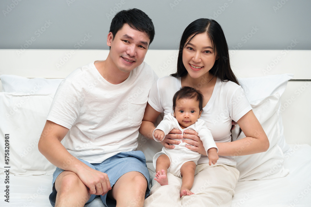 happy family (father and mother and baby) on bed happy family (father and mother and baby) on bed