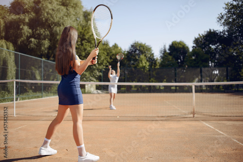 Two female tennis players on a tennis court during the match