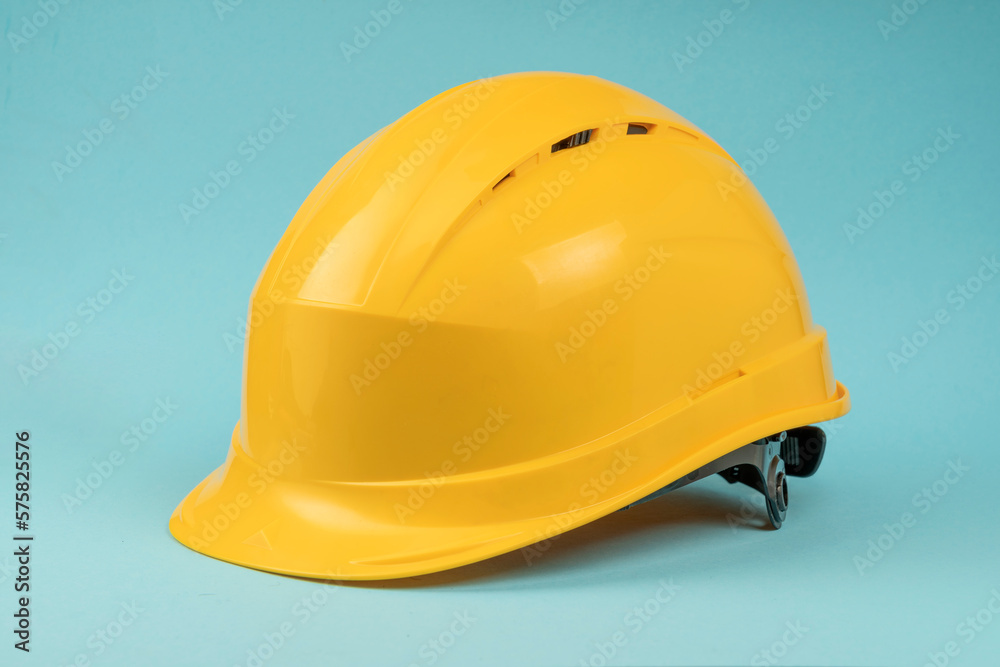 Fototapeta premium Construction helmet yellow on a blue background. Construction concept