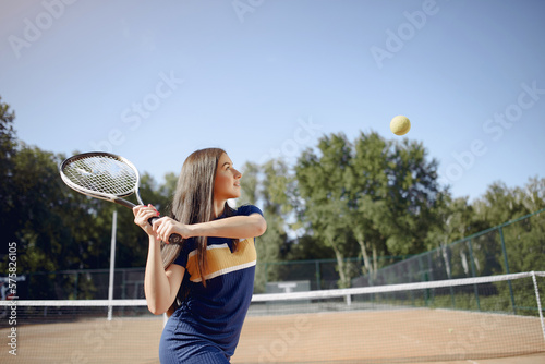 Caucasian female tennis player playing on the court outdoors © prostooleh