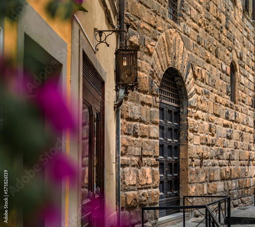 Fotografia Gothic buildings and flowers on an old street in Centro Storico, Florence, Italy