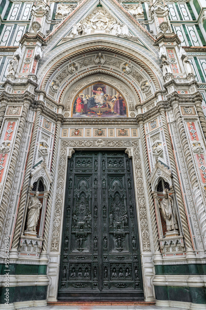Ornate doore and marble facade of the famous Duomo Cathedral in Florence, Italy