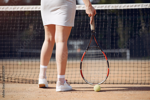 Cropped photo of legs of female tennis player who holding a racket