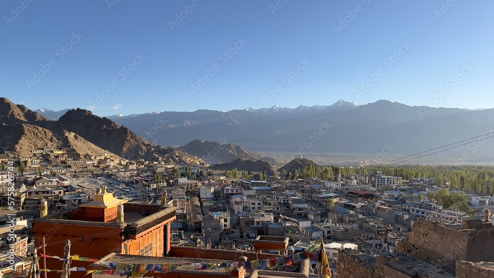 Beautiful sunset at Leh town seen from above with many houses and mountains surrounded at Ladakh, in the Indian Himalayas.