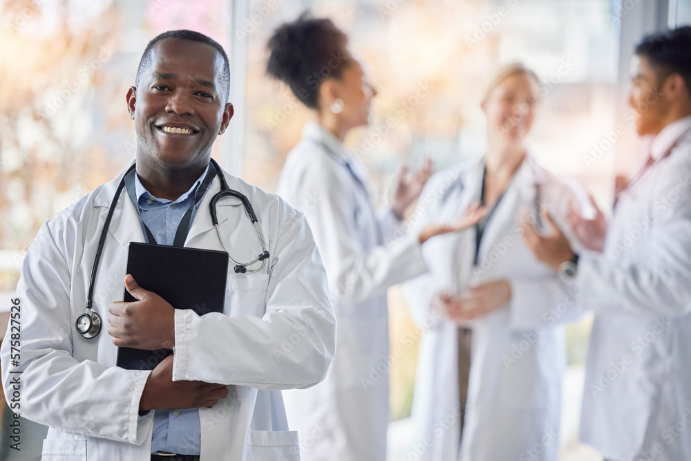 Black man, doctor portrait and tablet with medical team in hospital ready for healthcare work. Wellness, health and medic employee in a clinic feeling happiness and success with blurred background Black man, doctor portrait and tablet with medical team in hospital ready for healthcare work. Wellness, health and medic employee in a clinic feeling happiness and success with blurred background