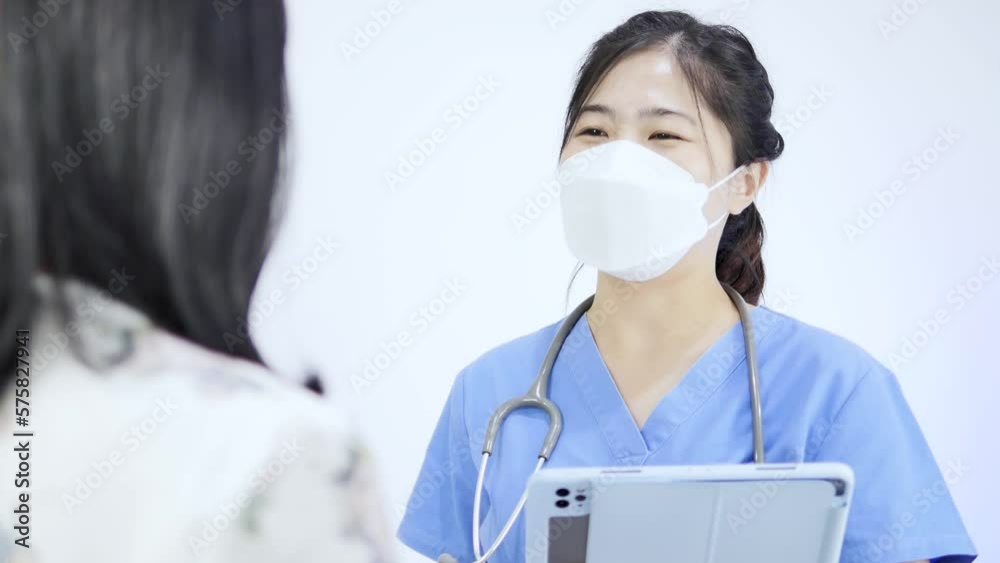 Close-up video of an Asian female doctor wearing a mask talking to a healthcare patient. Close-up video of an Asian female doctor wearing a mask talking to a healthcare patient.