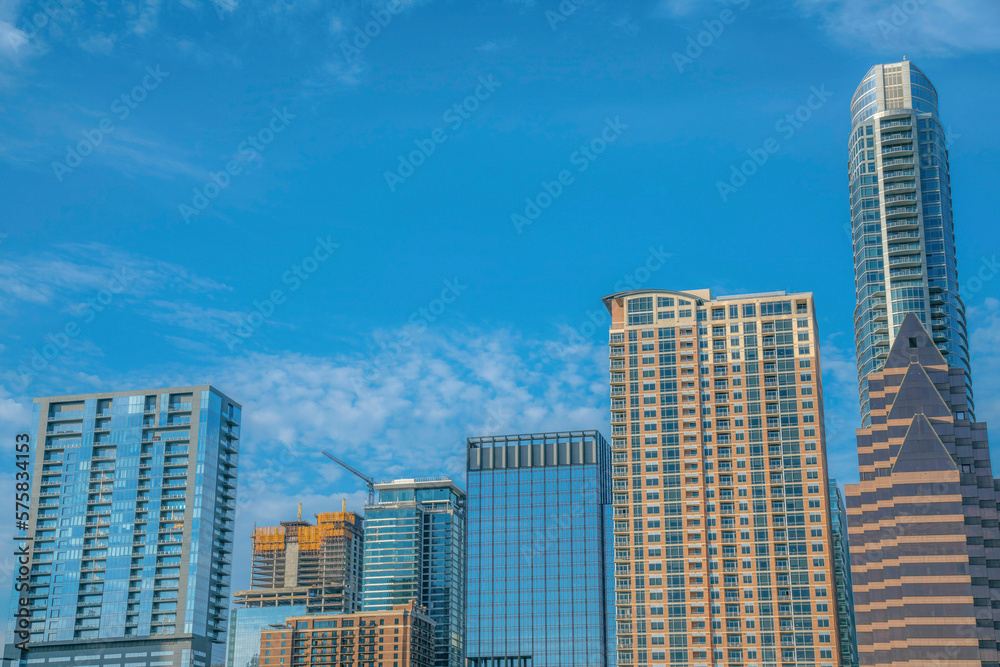 Apartments and corporate buildings under the blue sky at Austin, Texas. Cityscape views with one building under construction in the middle.