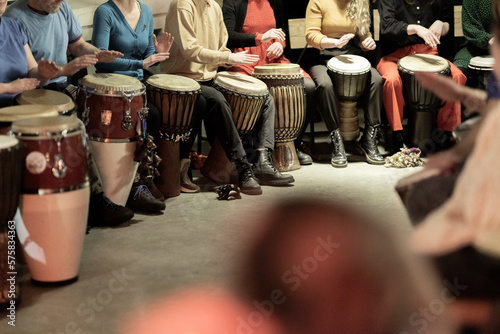 Fotografi A large group of people playing the conga drums in a relaxed setting