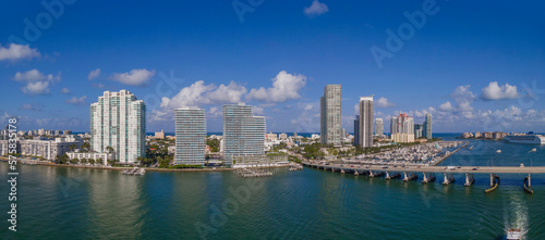 Panoramic view of the Miami Beach Florida skyline and the Intracoastal Waterway. The modern buildings has a magnificent view of the manmade inland water channel and blue sky.