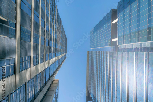Austin, Texas- High-rise buildings with a reflection of the sun on its glass walls. Two modern building structures with glass walls and a blue sky background.