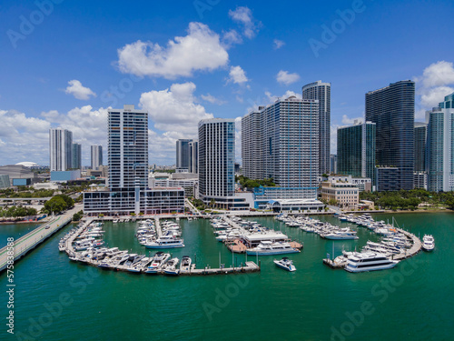 Sea Isle Marina at Intracoastal Waterway in beautiful Miami Beach Florida. Boats anchored above inland water channel with city skyline, blue sky, and clouds in the background. © Jason