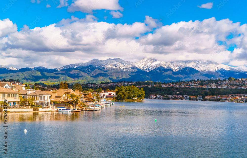Scenic Lake Mission Viejo with snow capped Santa Ana Mountains in the distance, after epic snowstorm in Southern California