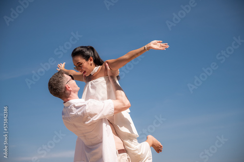 happy couple jumping on the beach romantic moments in honeymoon trip.