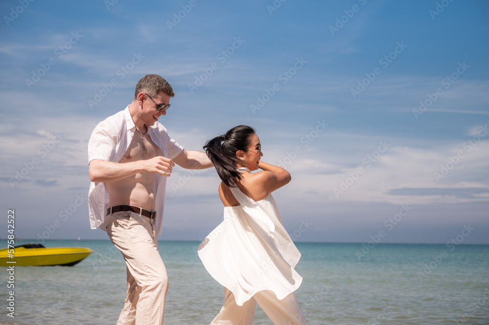 happy couple jumping on the beach romantic moments in honeymoon trip. happy couple jumping on the beach romantic moments in honeymoon trip.