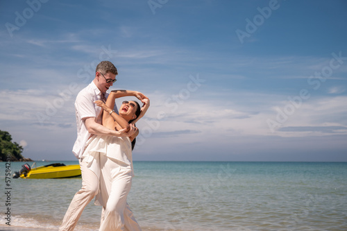 happy couple jumping on the beach romantic moments in honeymoon trip.