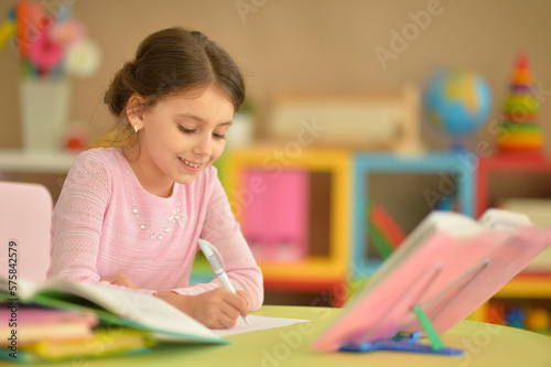 little girl doing homework at the table at home