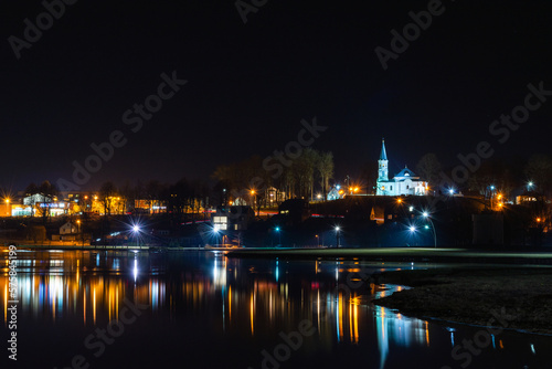 Telsiai town,water night lake in Lithuania. Nice view winter of colorful houses on coast of frozen Lake.Nice winter night.Town colorful light reflections on water.Long exposure.