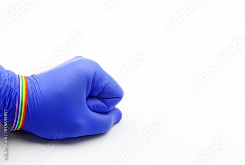 Fist with purple glove, with a pride bracelet, on a white background