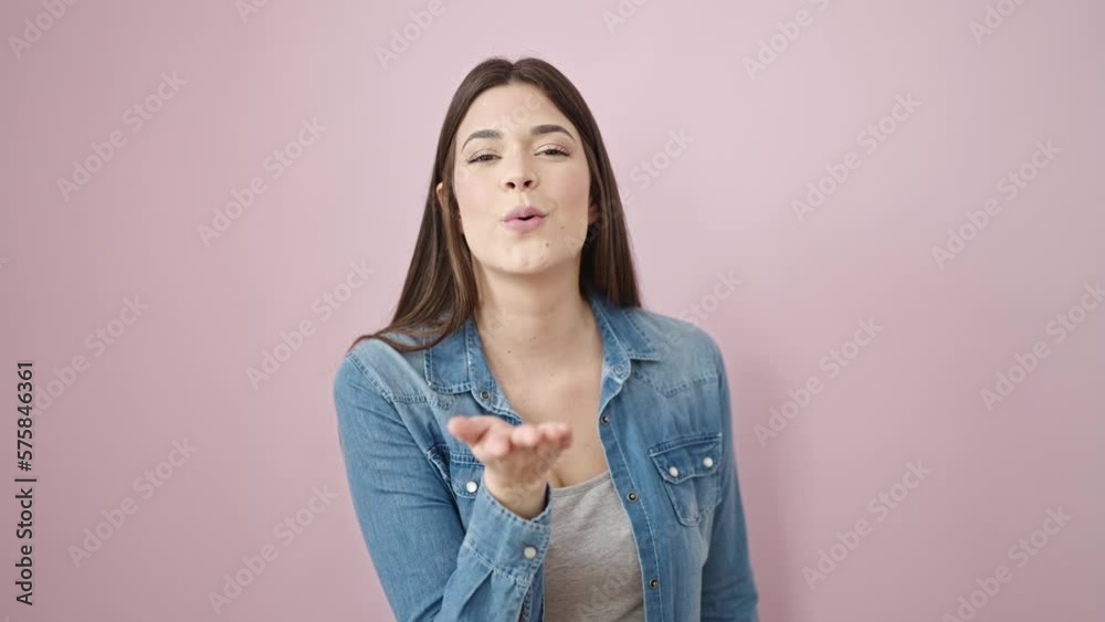 Young beautiful hispanic woman smiling confident blowing kiss over isolated pink background Young beautiful hispanic woman smiling confident blowing kiss over isolated pink background