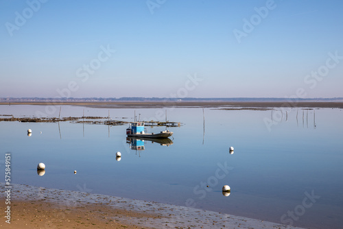 Oyster collecting boat in french atlantic coast bay in Bassin d'arcachon low tide
