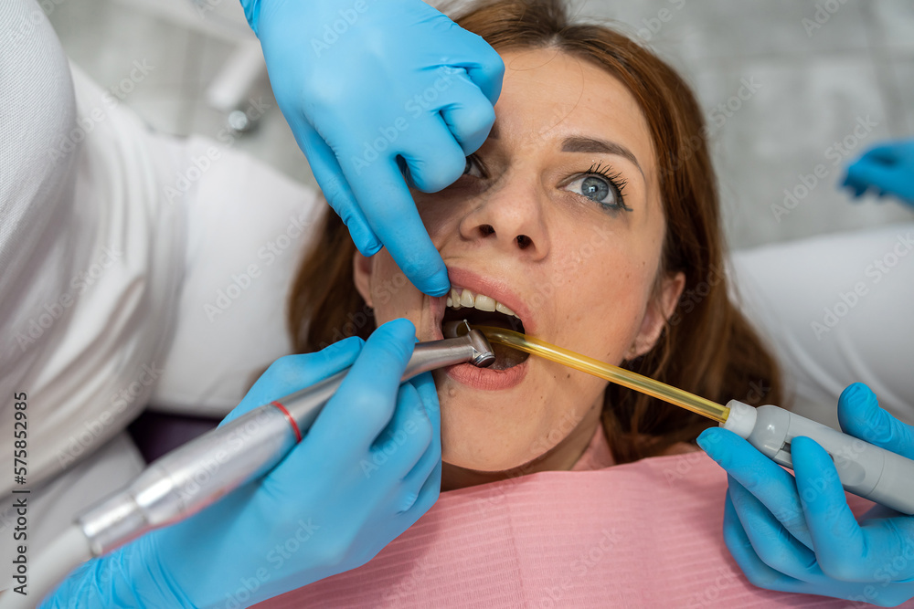 Close-up cropped photo of woman with open mouth holding mirror for dental equipment. Close-up cropped photo of woman with open mouth holding mirror for dental equipment.