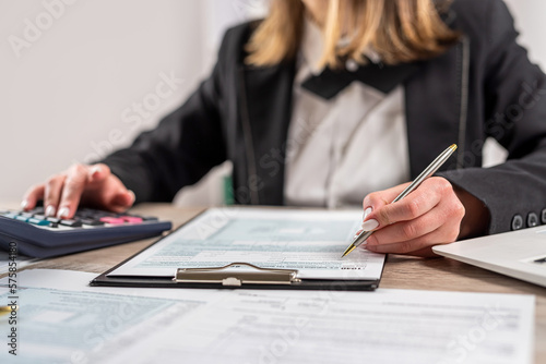businesswoman filling out the 1040 tax form 2022. financial paperwork concept