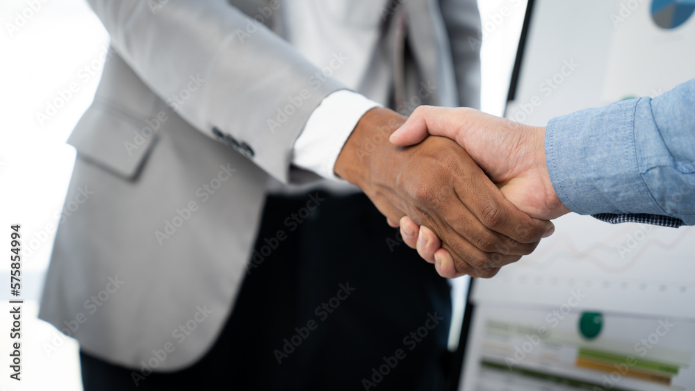 Two young Asian businessmen shake hands and agree to invest in a joint venture related to real estate. , Insurance income in the office.