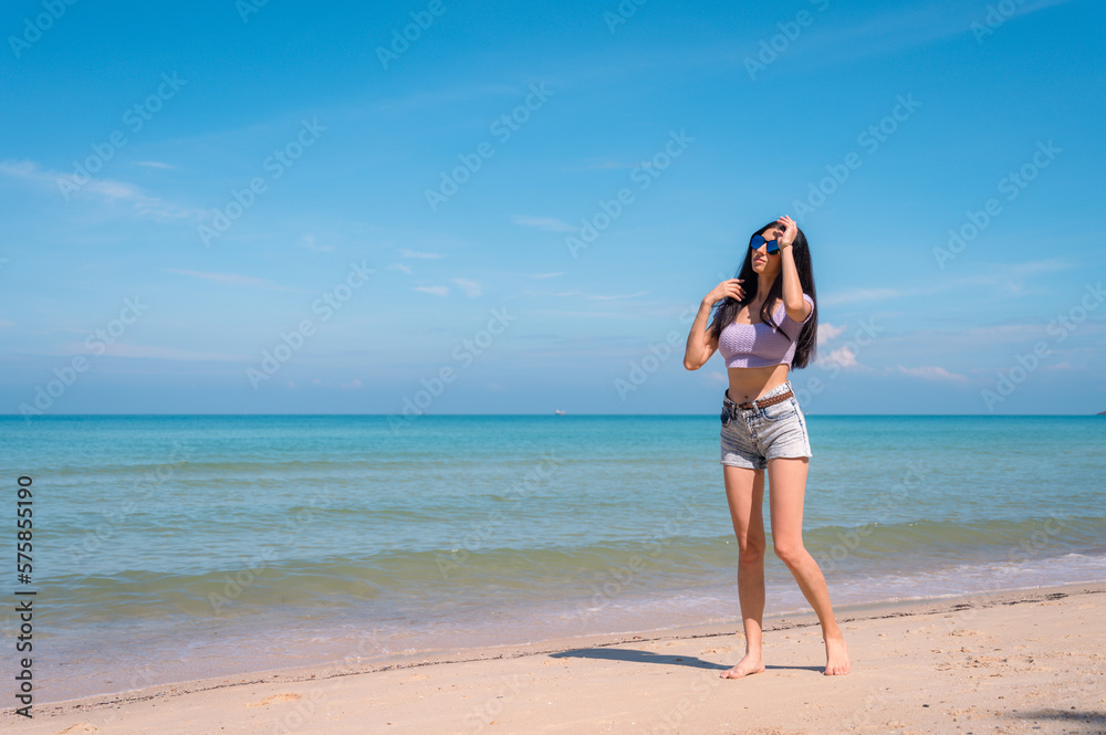 Summer lifestyle portrait of young girl enjoying on the tropical island. In the background the sea. Wearing Crop tops and shorts relaxed, Straight long hair.summer travel concept. Summer lifestyle portrait of young girl enjoying on the tropical island. In the background the sea. Wearing Crop tops and shorts relaxed, Straight long hair.summer travel concept.