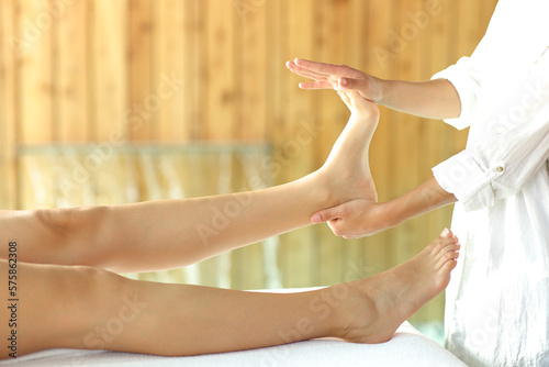 Woman receiving a reflexotherapy massage on foot photo