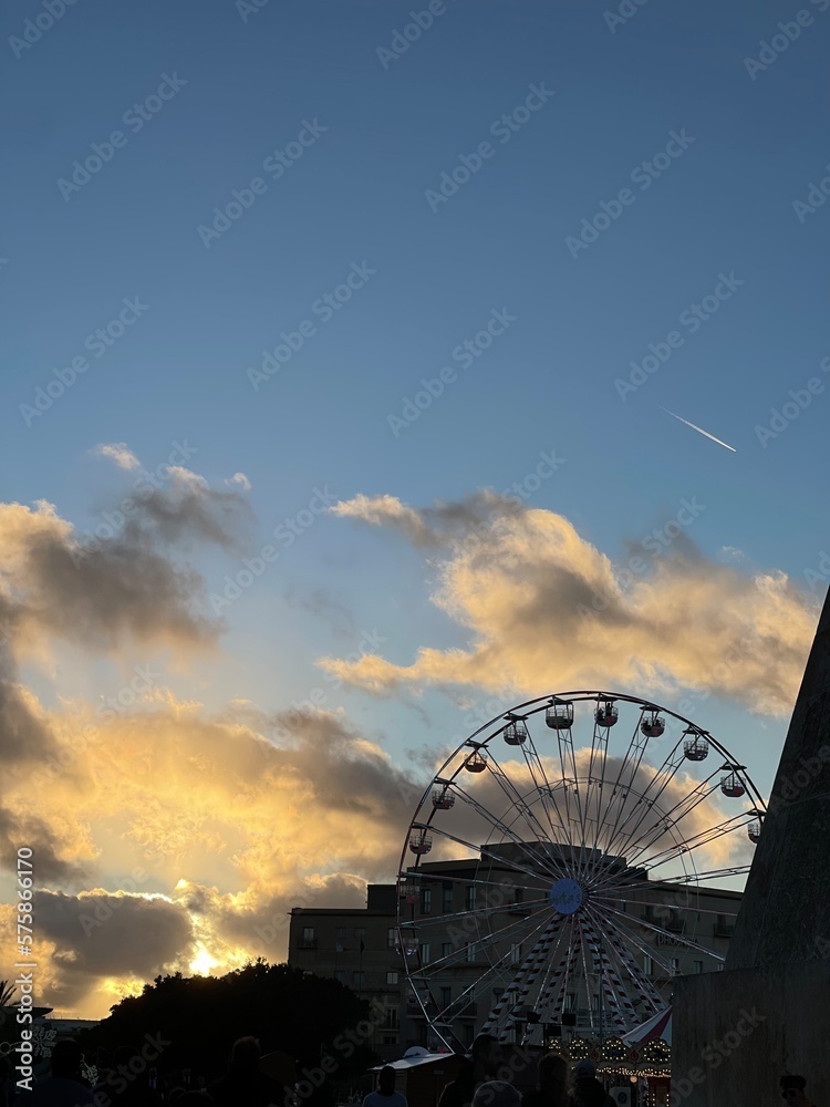 Blue sky on sunset with sun lights and orange colors. View of wheel look around on background of the sky