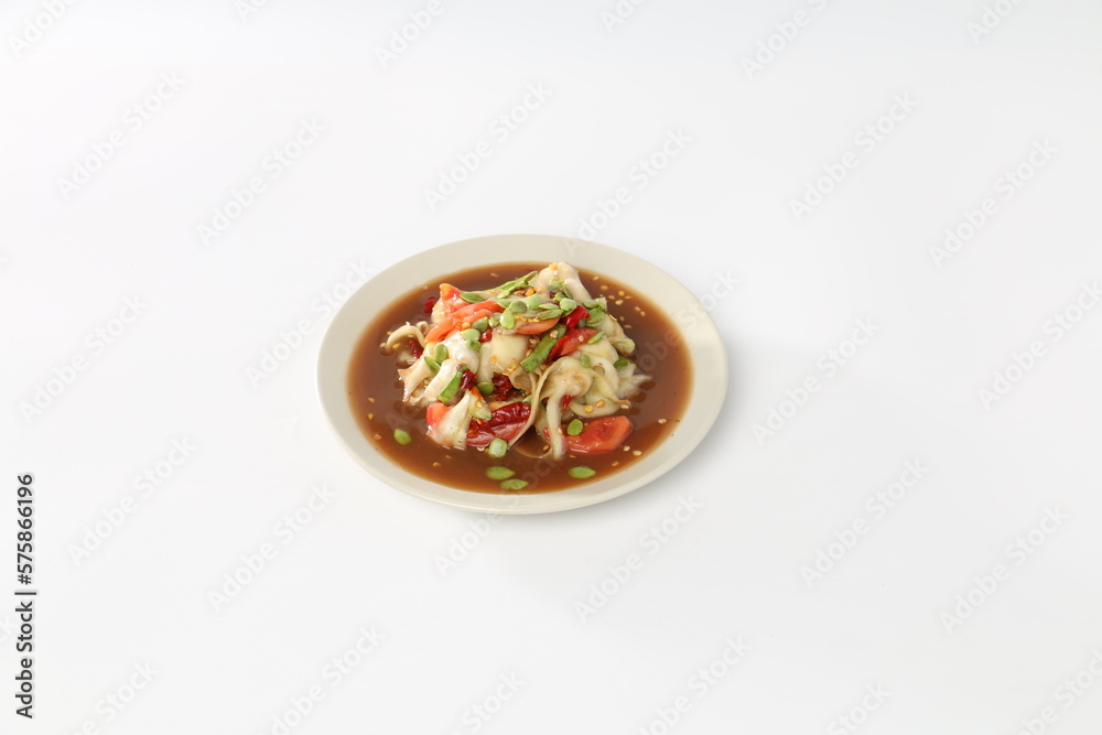 Papaya salad with pickled fish in a white dish.