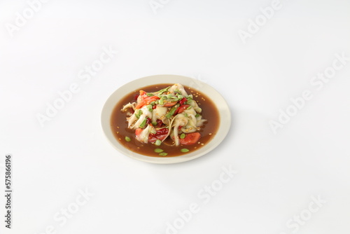 Papaya salad with pickled fish in a white dish.