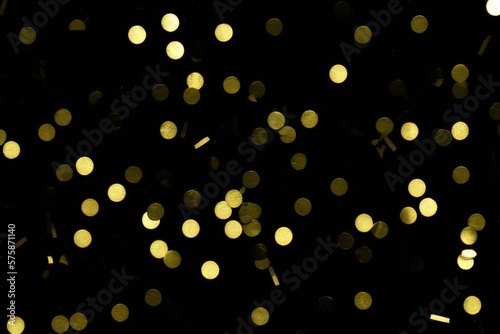 gold confetti on black background created with generative AI
