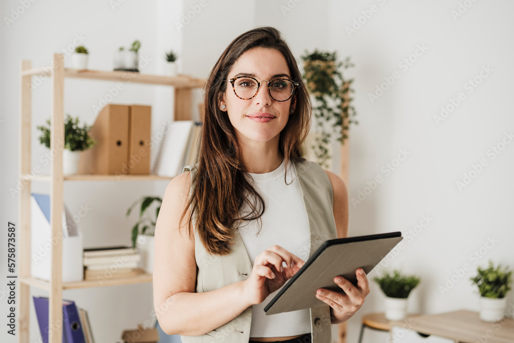 Smiling businesswoman standing with tablet PC in office Smiling businesswoman standing with tablet PC in office