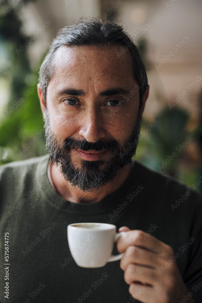 Smiling bearded man holding coffee cup Smiling bearded man holding coffee cup