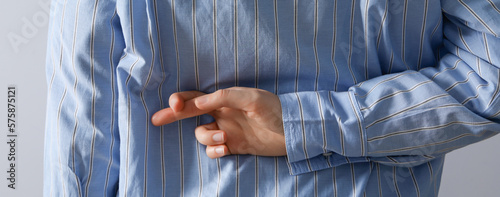 Photos Concept of excitement, woman holds crossed fingers behind her back