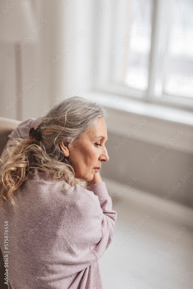 Contemplative woman with gray hair at home Contemplative woman with gray hair at home