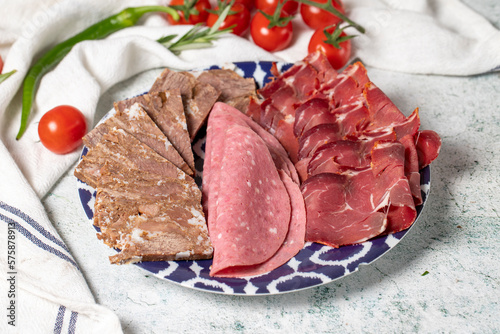 Cold Smoked Meat Plate, antipasto set platter. Roasted meat, salami and bacon on gray background