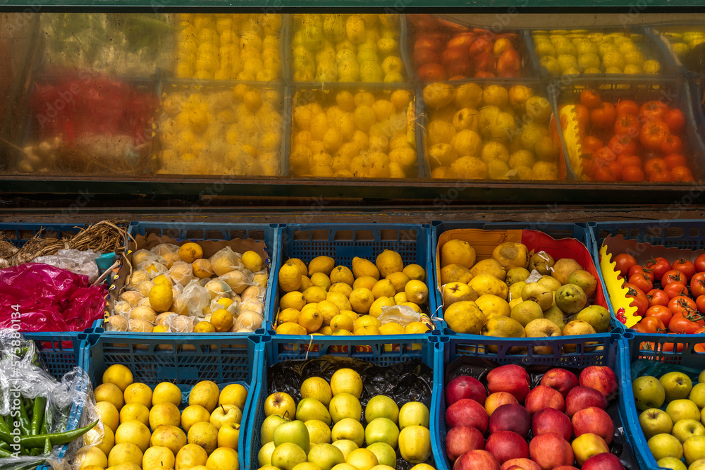 Grocery store counter on the street. Fruits and vegetables in the blue boxes. 