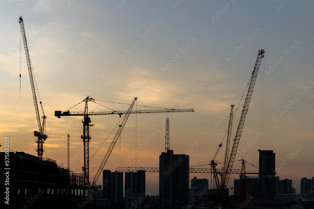 Silhouette construction large construction site including several cranes working industry construction cranes and buildings and sunset.