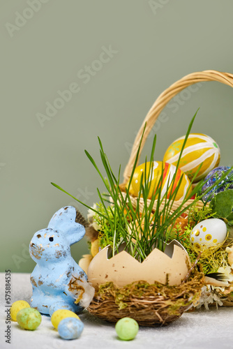 Happy easter day on april  Easter eggs and candy bunny  natural egg with growing wheat in the nest. Selective focus. Copy space