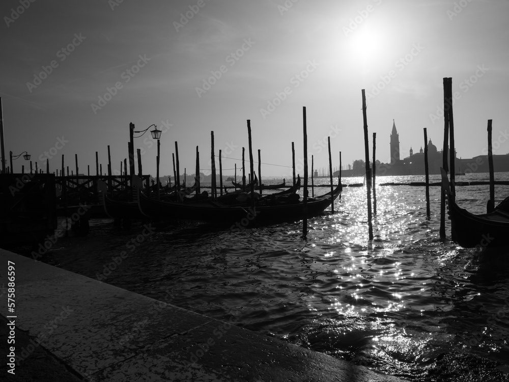 Black and white photo of gondolas moored in the grand canal in Venice.