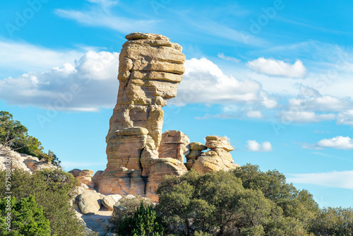 Hanging stone rock formation in the hills and cliffs of the arizona mountains and desert in afternoon sun with trees