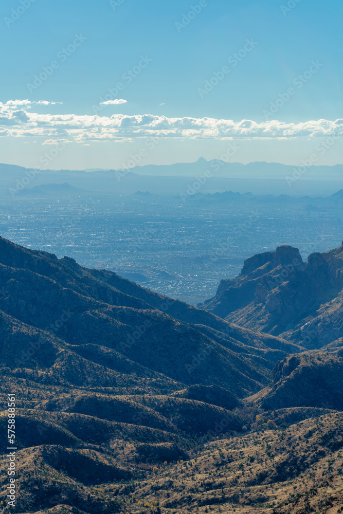 Rolling ridge hills in the cliffs and wilderness of arizona in tuscon with hazy cloud skies blue and shadow wilderness