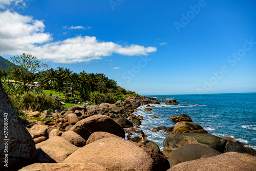 Side view of rocky beach and intense blue sea in Ilhabela