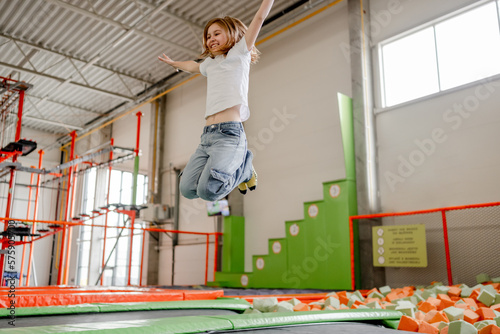 Fototapeta Naklejka Na Ścianę i Meble -  Pretty girl in trampoline park having fun