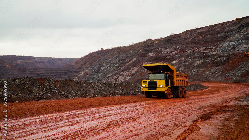 dump truck transporting iron ore in red iron ore quarry. The red quarry looks like the planet Mars dump truck transporting iron ore in red iron ore quarry. The red quarry looks like the planet Mars