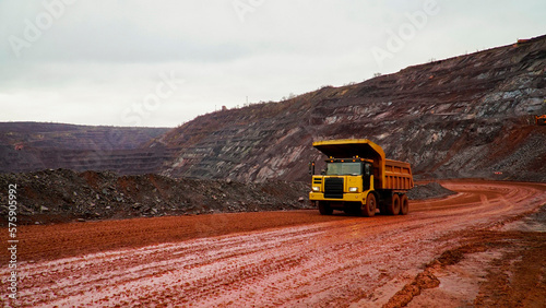 dump truck transporting iron ore in red iron ore quarry. The red quarry looks like the planet Mars