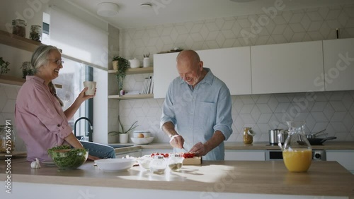 Happy senior couple cooking together at home.