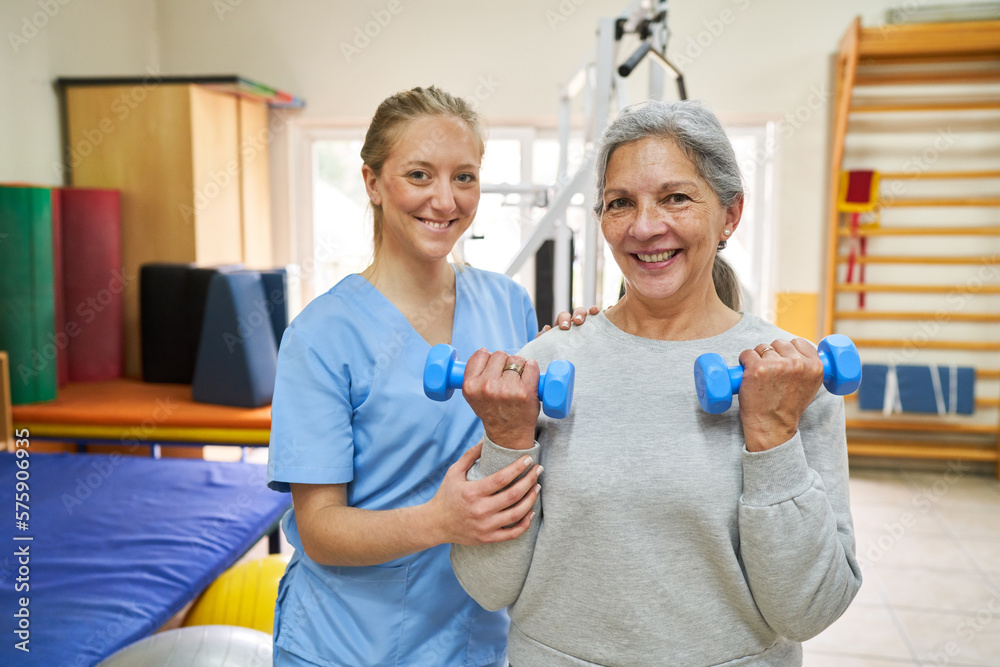 Therapist assisting senior woman exercising with dumbbells Therapist assisting senior woman exercising with dumbbells